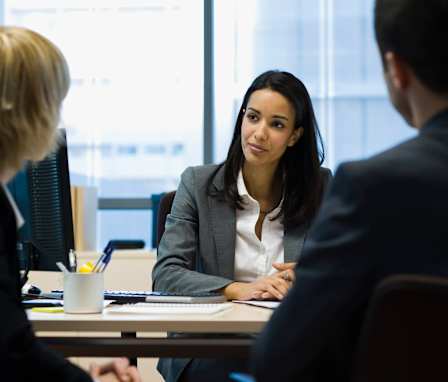 Three executives talking around a desk